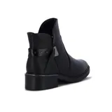 Bota de cuero negro de caña baja, con elástico lateral y aplique metálico decorativo.
