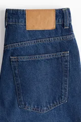 Jeans de cinco bolsillos en denim de algodón lavado, color azul medio. Modelo de tiro alto con piernas rectas de corte holgado y cierre con botón.