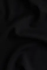 Remera corta negra de punto fino suave, entallada con cuello redondo ribeteado acanalado.