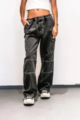 Pantalón cargo de jean celeste con lavado esfumado, tiro bajo, pierna ancha y bolsillos cargo.