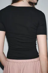 Camiseta color crema de tejido de punto rib, corte slim fit, escote en pico con detalle de encaje y mangas cortas.