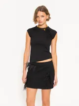 Minifalda negra de tejido de punto con corte ajustado a la cadera y detalle de plumas aplicadas en los laterales.