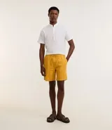 Bermuda de playa recta color mostaza, con textura de rayas y lazo en la cintura.