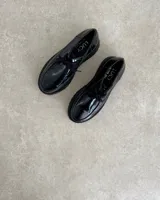 Zapato mocasín acordonado de cuero color marrón, con suela track negra y detalle de ribete color crema.