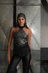 Top negro de encaje con cuello halter, espalda descubierta y flecos en el ruedo.
