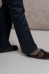 Pantalón de tiro medio con fit flare, color negro engomado.