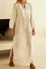 Vestido blanco de mangas largas con volados en el escote y lazo de ajuste.