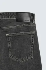 Pantalón de jean negro con efecto lavado, corte bootcut, tiro medio y cinco bolsillos.