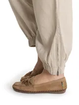 Pantalón de lino color beige, tiro alto, corte ancho, con bolsillos laterales y elástico en los tobillos.