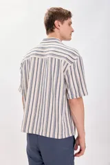 Camisa casual de manga corta con cuello solapa y cierre abotonado. Diseño a rayas verticales en tonos crudo y azul.