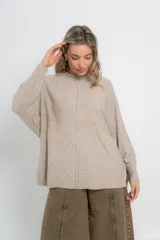 Sweater color crudo de corte holgado, con cuello redondo y terminaciones acanaladas en puños y ruedo.