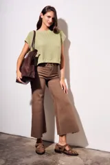 Chaleco de punto color beige con lurex, de corte recto y mangas cortas. Tejido calado con pequeños agujeros.