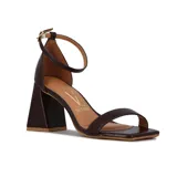 Sandalia de mujer marca Vizzano, color marrón oscuro, con una tira ancha en la parte delantera y una tira fina ajustable con hebilla en el tobillo. Posee un taco ancho y geométrico de altura media.