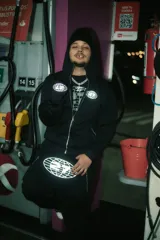 Conjunto deportivo negro compuesto por campera con cierre y pantalón jogging, ambos con logo estampado en blanco.
