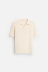 Polo color crema de punto, corte regular fit, cuello solapa con abertura frontal y manga corta.