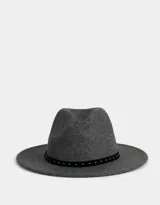 Sombrero fedora gris con cinta negra decorada con tachas plateadas.