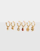 Set de seis aros tipo argolla dorados con dijes colgantes: corazón con strass, abeja, herradura con strass, mariquita, herradura y trébol de cuatro hojas.