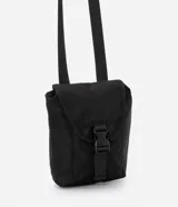 Bolso mini tipo bucket color negro, hecho en poliamida sin estampa. Tiene cierre delantero con tirador y cordón elástico, y tapa con enganche.