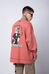 Buzo color crema de corte oversize confeccionado en tela friza con cuello redondo y puños y cintura acanalados. Presenta un pequeño bordado en el frente y un estampado grande en la espalda.