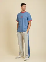 Pantalón de jogging azul con banda lateral celeste y logo de la marca bordado en blanco.