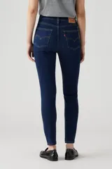 Pantalón de jean azul oscuro, tiro alto, corte skinny y tobillo al ras.