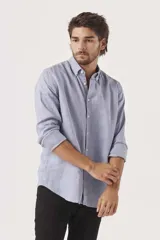 Camisa de lino color blanco, de corte regular, con cuello clásico y mangas largas.