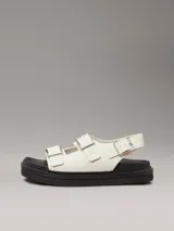 Sandalias de piel lisa color blanco con suela de goma negra, tiras anchas con hebillas metálicas ajustables y plantilla moldeada.
