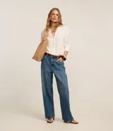 Pantalón wide leg de jeans azul con cintura alta, trabillas en la cintura y friso delantero.
