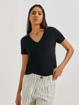 Remera gris de corte clásico, con cuello en V y mangas cortas.