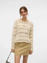 Sweater de punto calado color crema, con cuello redondo y mangas largas. Diseño holgado y tejido liviano.