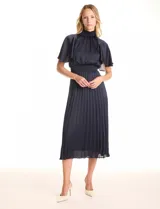 Vestido midi plisado color azul marino de la marca Julia Jordan. Presenta cuello alto con punto smock, mangas amplias tipo capa, espalda con botones y abertura central, y cintura elastizada en punto smock. Incluye forro interno a tono.