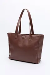 Cartera tipo tote bag en símil cuero color marrón oscuro, con bordados decorativos en blanco que evocan un estilo western. Cuenta con asas largas para llevar al hombro.
