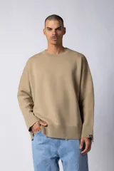 Sweater beige de hilo de algodón, corte oversize, con cuello redondo, puños y ruedo acanalados con pequeños desgastes. Espalda con logo tejido.