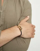 Pulsera de cuero trenzado color negro con cierre de mosquetón doble entrelazado bañado en oro de 18k.