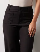 Pantalón de jean blanco de pierna ancha, tiro alto, pretina con pasadores, botón y cierre. Delantera y trasera con bolsillos.