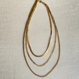 Collar dorado de triple cadena con dije de estrella.