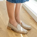 Mocasines negros de cuero con textura tipo reptil, punta cuadrada y detalle de aplique de cuero liso en el empeine.