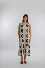 Vestido midi color crema con estampado de óvalos negros, de un solo hombro y corte holgado.