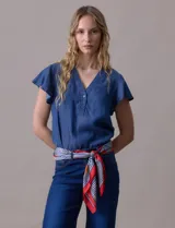 Blusa celeste de tencel con escote en V y botones. Tiene mangas cortas amplias con volados.