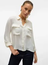 Camisa color crudo de corte recto, con cuello clásico, manga larga con puños abotonados, cierre frontal con botones y dos bolsillos de parche en el pecho.