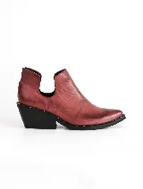 Botín de cuero color ladrillo con puntera fina, laterales con corte en V y taco cuadrado negro con detalle de tachas.