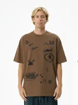 Remera de manga corta color marrón con cuello redondo y estampado gráfico en negro que incluye figuras marinas (peces, corales) y texto.