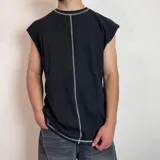 Musculosa negra de corte holgado con costuras blancas a la vista en cuello, sisas y ruedo.