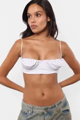 Top brassier blanco de microfibra pesada con forrería en microfibra liviana. Escote balconette con frunce en la parte superior de las tazas. Tazas forradas con paso de aro interno a través de cinta vaina. Breteles regulables embutidos en la prenda.