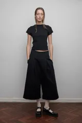 Camiseta negra de corte ajustado, con mangas cortas y espalda de tul transparente. Diseño versátil que permite usarla tanto de frente como de espalda.