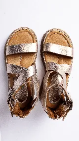 Sandalias de cuero color plateado con tiras anchas, hebillas metálicas y suela track color caramelo.