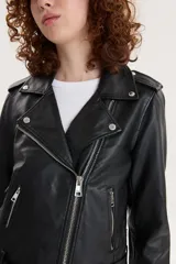 Campera biker negra de cuero sintético con cuello solapa, cierre cruzado con cremallera, bolsillos con cremallera y cinturón ajustable.