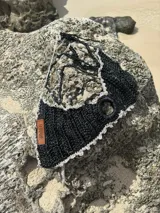 Top tejido a crochet color negro, con terminaciones en crochet color gris y tiras con perlas.