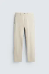 Pantalón de vestir color beige, corte slim fit, con bolsillos laterales y traseros con botón.