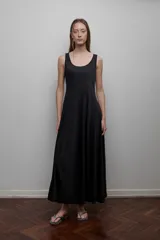 Vestido largo negro de corte evasé, sin mangas y escote redondo. Incluye un pañuelo gris claro.